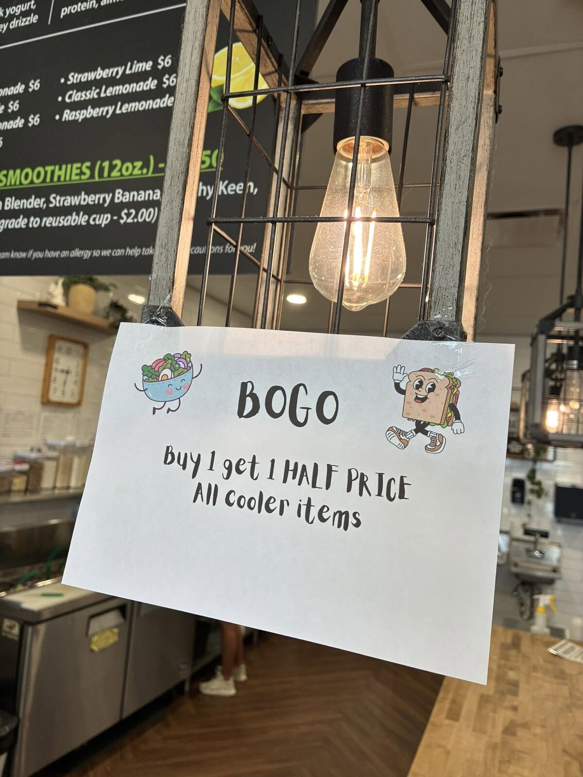 The BOGO sign under the lamp: buy 1 get 1 half price, all cooler items