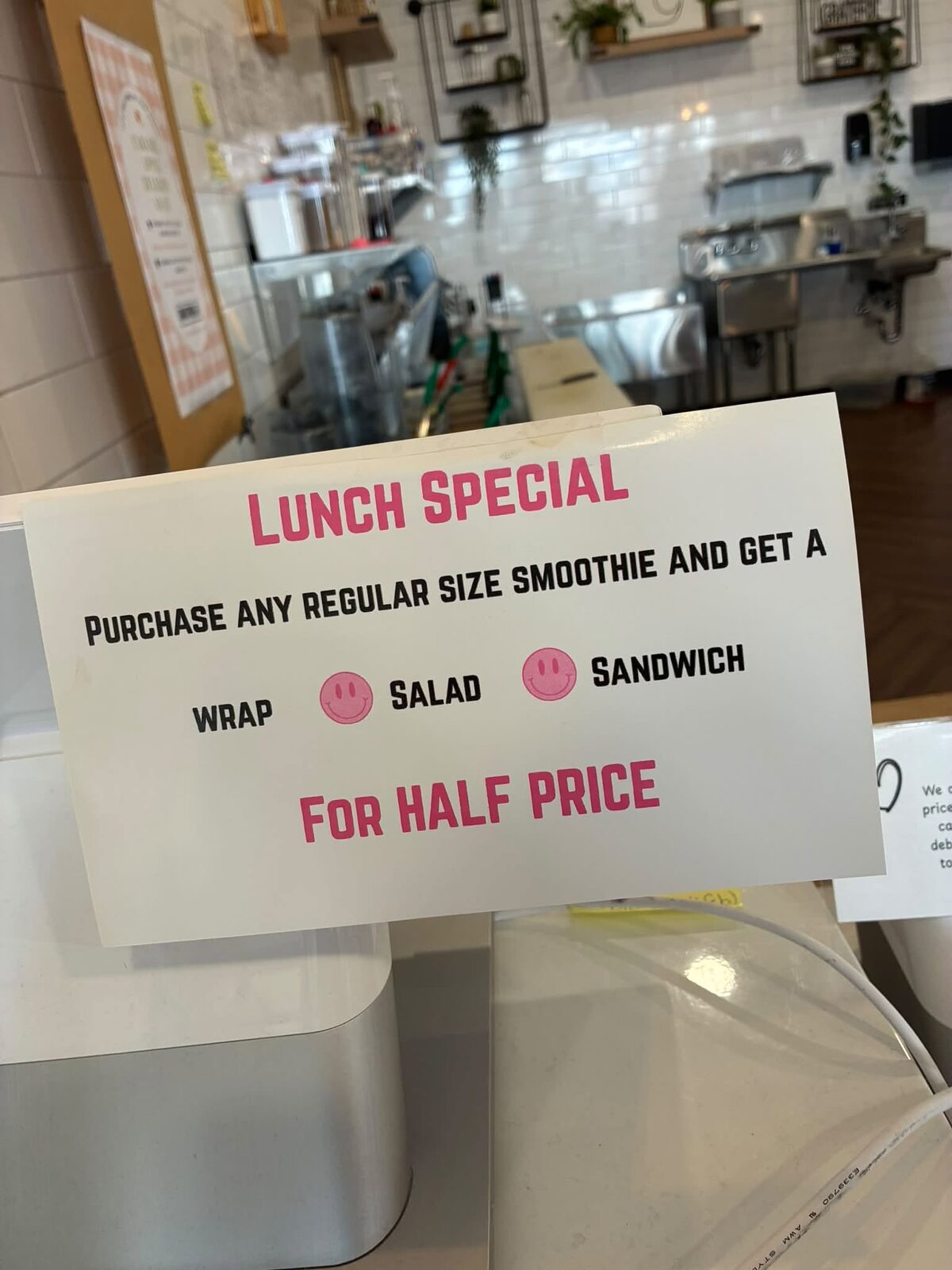 The lunch special sign on the counter: purchase any regular size smoothie and get a wrap, salad or sandwich for half price
