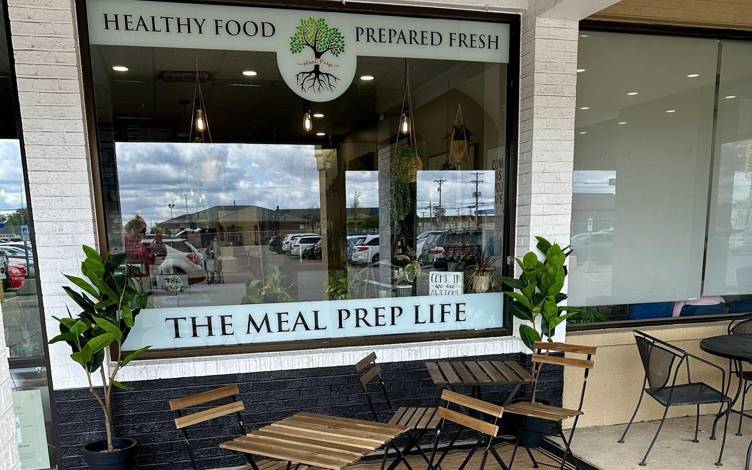 The shopfront in Sidney Towne Center: the big window, the tables outside, the tree logo over the door