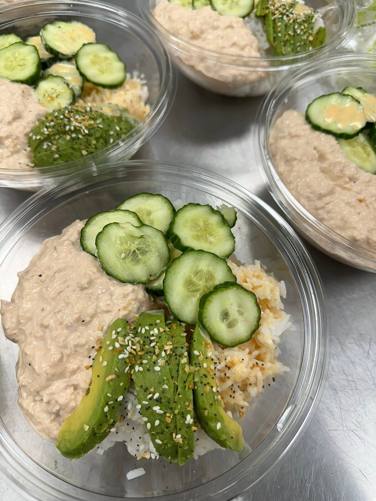 Tuna salad with cucumber slices and avocado in a to-go box