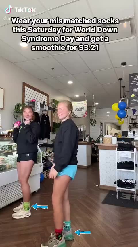 Two of the team in mismatched socks in the shop — her reel about World Down Syndrome Day